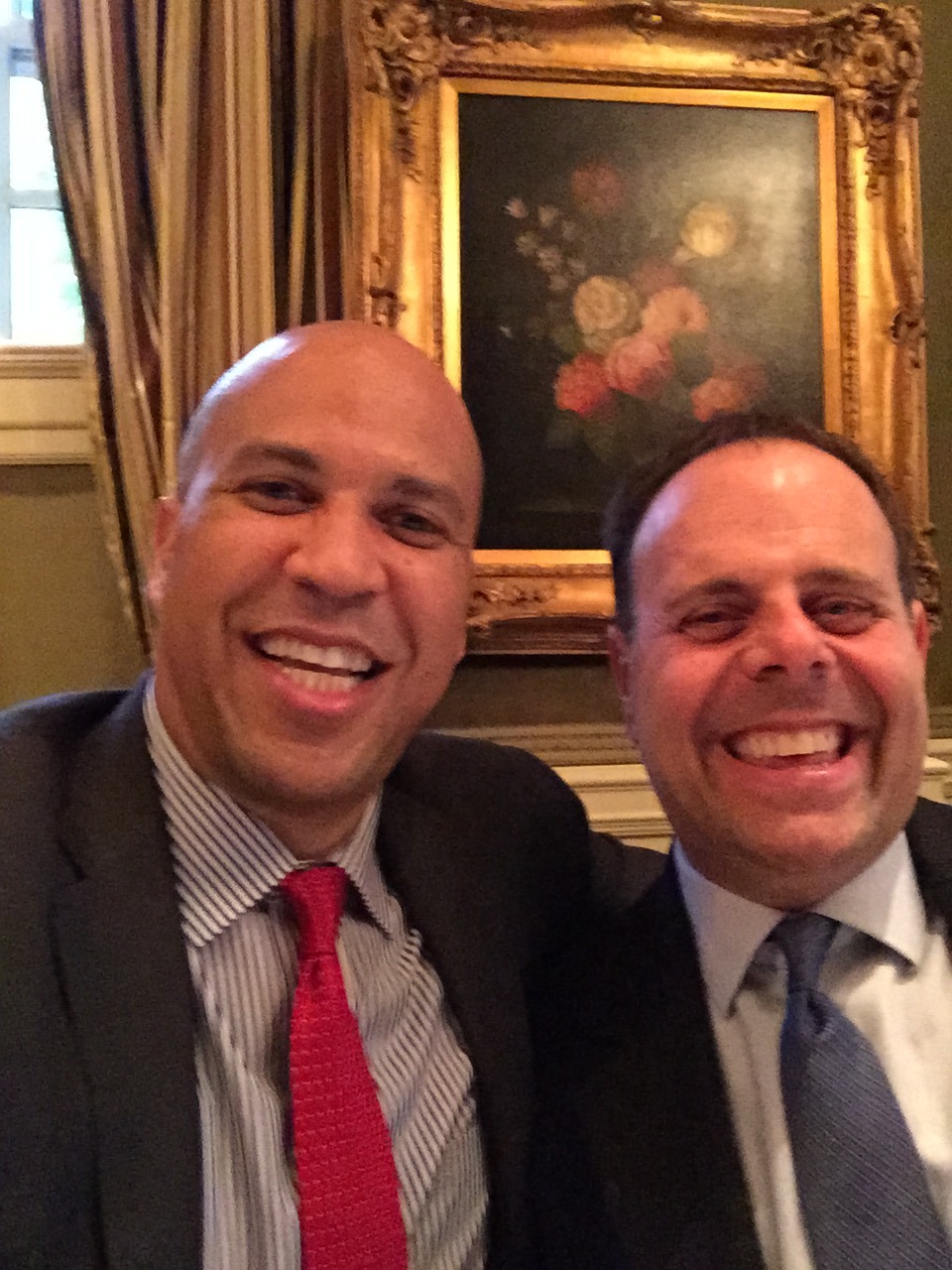 Aaron Yelowitz and Senator Cory Booker smiling for a photograph at the Jefferson Hotel in Washington, D.C.